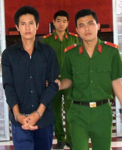 Bị cáo Trịnh Nhân ra tòa dưới sự áp giải của công an.