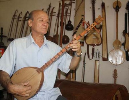 Nghệ nhân Võ Văn Bá bên những sản phẩm nhạc cụ làm từ dừa của mình. Ảnh: Internet