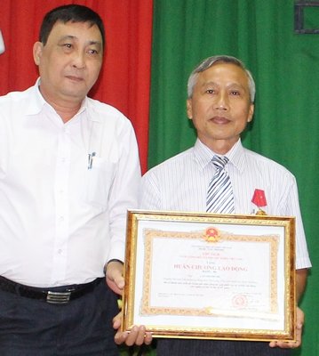 Ông Ngô Minh Đông- Phó chánh văn phòng Tổng LĐLĐ Việt Nam trao Huân chương Lao động Hạng 3 của Chủ tịch nước cho ông Cao Thanh Chí. 