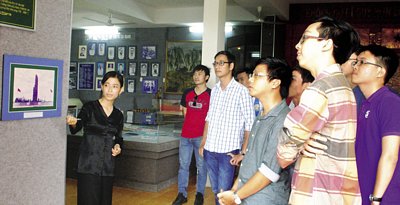 Nhóm cựu học sinh Trường THPT chuyên Nguyễn Bỉnh Khiêm nghe thuyết minh ở Khu căn cứ cách mạng Cái Ngang.