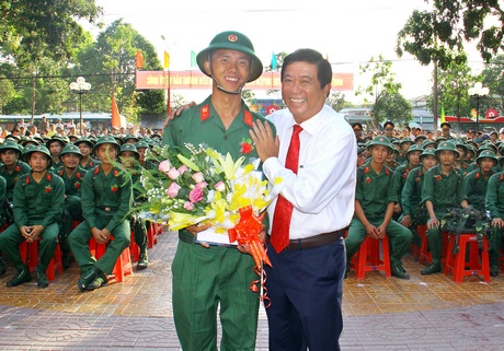 Bí thư Huyện ủy Vũng Liêm- Bùi Văn Nghiêm trao quyết định và tặng hoa cho tân binh là đảng viên.