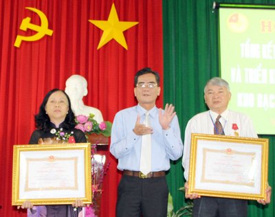 Ông Lê Quang Trung- Phó Chủ tịch Thường trực tỉnh trao Huân chương Lao động cho 2 cá nhân.