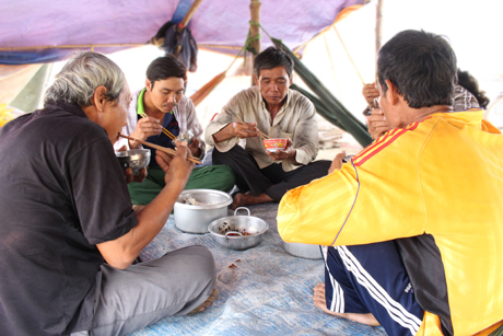 Những người phơi lúa mướn ăn trưa tại chiếc lều ngay tại sân lúa.