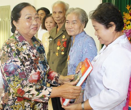 Bà Phạm Thị Đào- Chủ tịch Hội NTKC thị xã tặng kỷ yếu cho các chiến sĩ cách mạng bị địch bắt tù đày. 