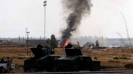 Khói bốc lên từ một ngôi nhà khi lực lượng người Kurd tấn công các chiến binh IS ở phía nam Kirkuk - Ảnh: EPA