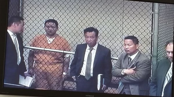  Minh Béo sau màn lưới thép tại phiên xử ngày 15.4. Bên cạnh là luật sư Đỗ Phủ, luật sư Nguyễn Anh Tuấn, và chánh biện lý Tony Rackauckus. (Ảnh: Ngọc Lan chụp qua màn hình TV tại toà).