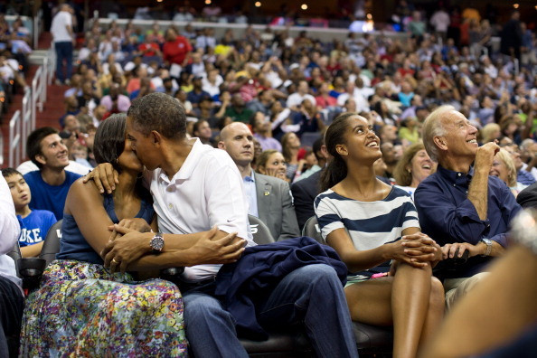 Ông Obama hôn bà Michelle say đắm trước ống kính máy quay khi dự khán một trận đấu bóng. (Ảnh: fabmagazineonline)