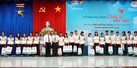 Giám đốc Ngân hàng Nhà nước Việt Nam tỉnh Vĩnh Long Nguyễn Trọng Nghiệp và lãnh đạo Kienlongbank Vĩnh Long trao học bổng cho các em.