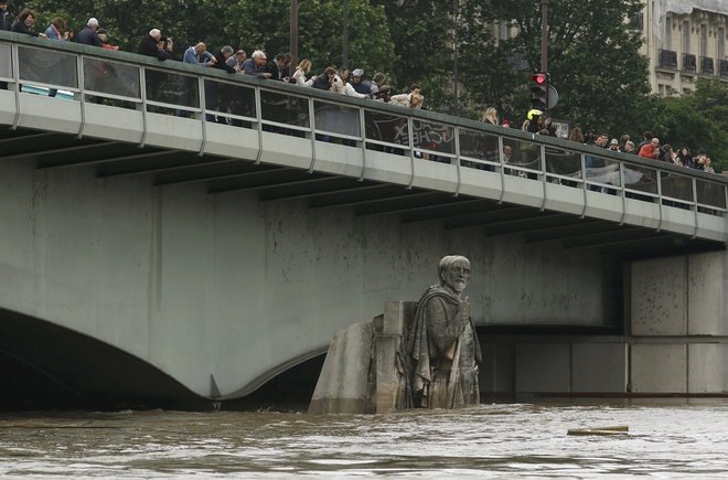 Người dân đang tập trung trên cây cầu bắc ngang sông Seine để xem cảnh tượng nước sông dâng cao lịch sử.