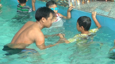 Trẻ em được thầy hướng dẫn kỹ năng bơi lội