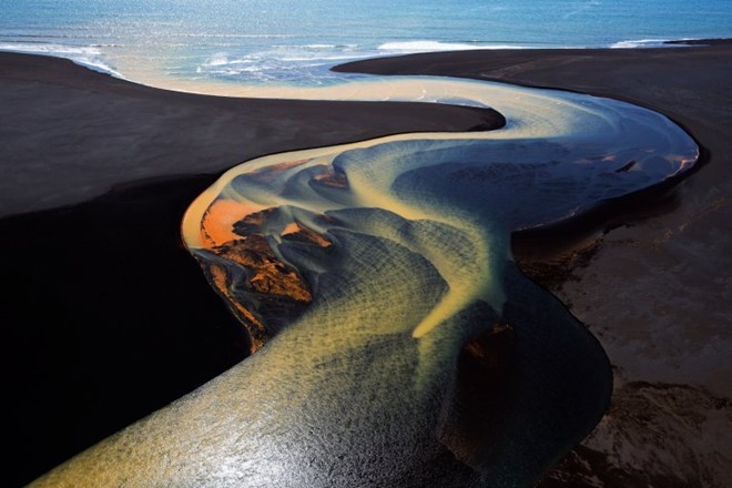 Một dòng sông uốn lượn trước khi đổ ra biển phía nam Iceland. Khoáng thể khiến mặt sông giống như bức tranh sơn thủy. Ảnh: Stephen King.
