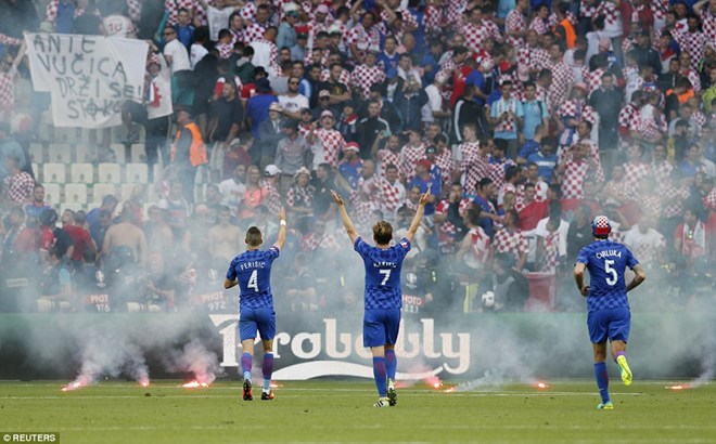Cổ động viên Croatia ném pháo sáng xuống sân bất chấp lời van xin của cầu thủ.