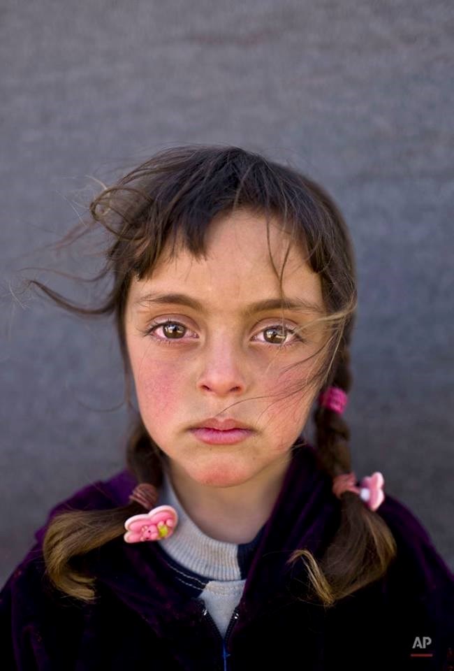 Zahra Mahmoud (5 tuổi), trẻ tị nạn người Syria, chụp ảnh ở khi lều tạm gần biên giới Syria và Jordan. (Nguồn: AP)