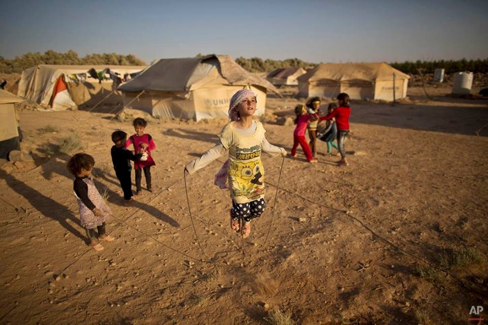 Zubaida Faisal (10 tuổi), bé gái tị nạn người Syria, chơi nhảy dây với các bạn ở khu trại tạm gần biên giới Syria và Jordan. (Nguồn: AP)