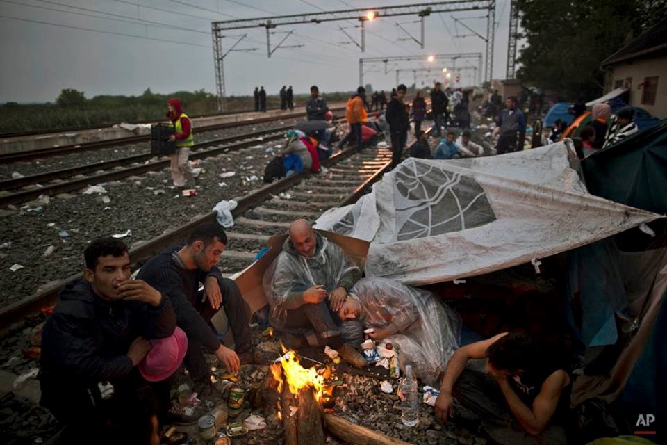 Những người tị nạn Iraq ngồi quanh đống lửa để tránh rét trong khi chờ tàu ở Tovarnik, Croatia. (Nguồn: AP)