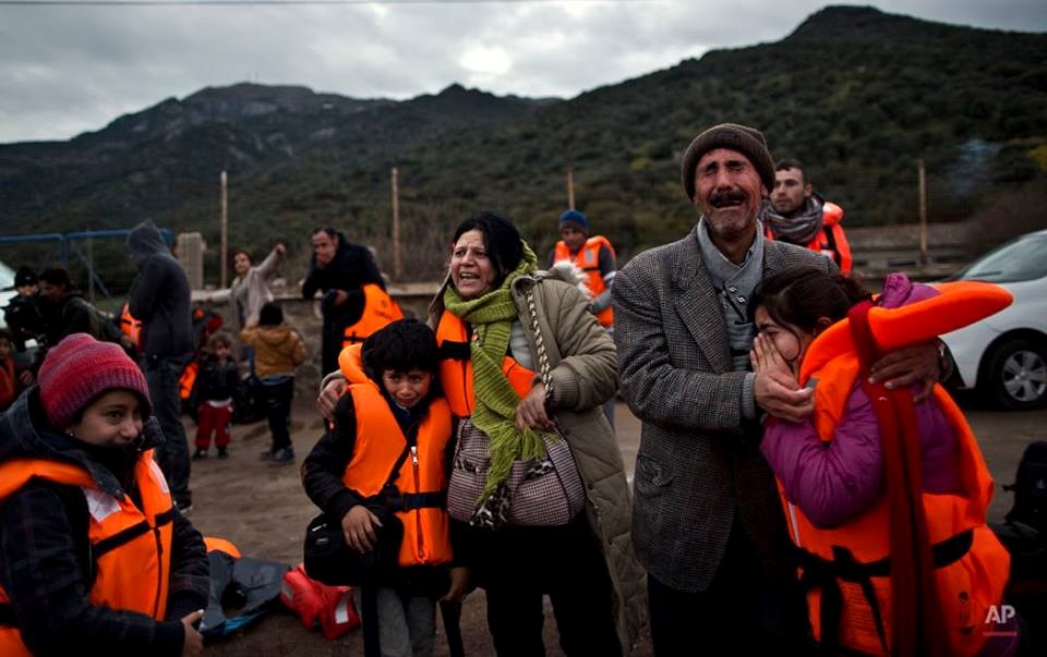 Ông Samir Qasu (45 tuổi) và vợ Bessi (42 tuổi) vừa ôm các con Dunia (13 tuổi) và Dildar (10 tuổi) vừa khóc. Gia đình này đến từ Iraq, họ vừa vượt biển Thổ Nhĩ Kỳ để tới Lesbos (Hy Lạp) an toàn. (Nguồn: AP)