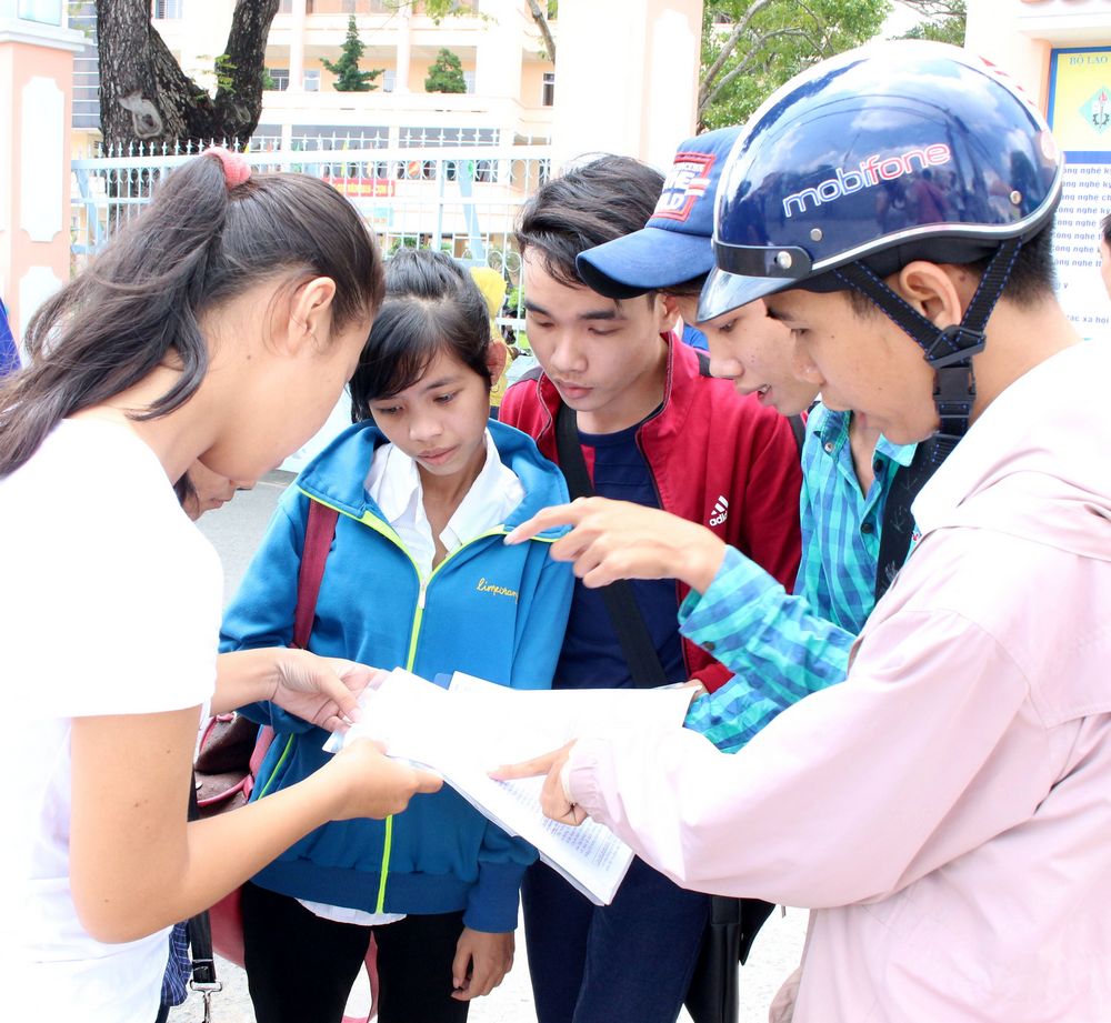 Thầy Huỳnh Quang Huy- Trường THCS- THPT Hòa Ninh, Long Hồ (đội nón) nghe học trò kể chuyện làm bài thi.