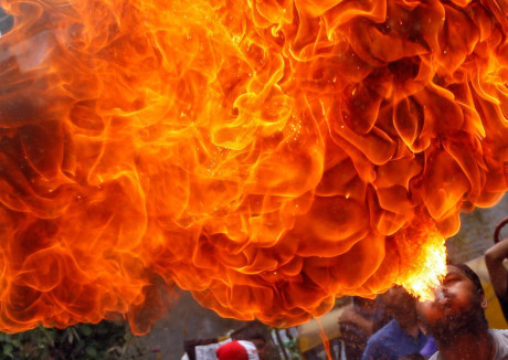 Một tín đồ đạo Hindo thực hiện một tiếc mục phun lửa nguy hiểm trong một buổi diễn tập cho lễ Rath Yatra hàng năm, hay còn gọi là lễ rước xe thánh, kỷ niệm cuộc hành trình của vị thần Jagannath của đạo Hindu, cùng anh trai Balabhadra và em gái Subhadra, trong một chiếc xe đặc biệt, tại Ahmedabad, Ấn Độ. (Nguồn: Sputnik)