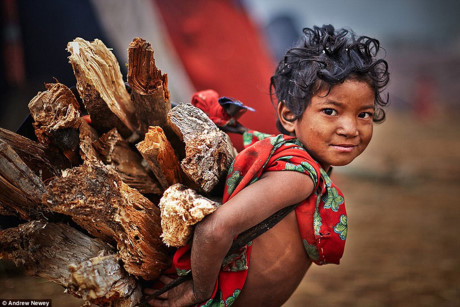 Trong bộ tộc, mọi người đều lao động bất kể tuổi tác, đóng góp sức mình cho cuộc sống chung. Trong hình, một đứa trẻ đang mang củi trên lưng.