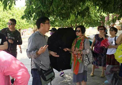 Hướng dẫn viên Trung Quốc dẫn đoàn khách tham quan chùa Linh Ứng (Đà Nẵng). (Ảnh: Hướng dẫn viên tiếng Trung cung cấp/VNE).