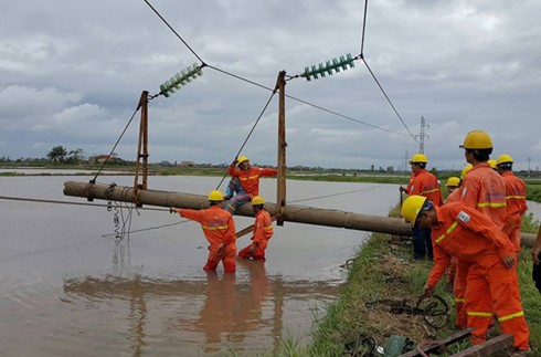 Công nhân ngành điện đang khắc phục lưới điện 35kV, dựng lại cột 35kV bị đổ tại địa bàn huyện Trực Ninh, tỉnh Nam Định.
