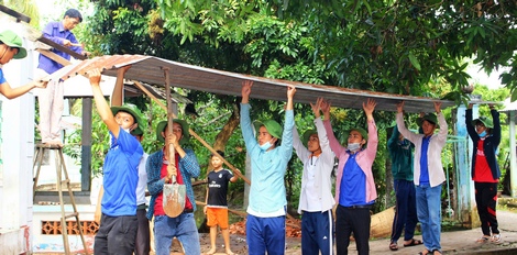 Các sinh viên tình nguyện Trường ĐH Cửu Long hỗ trợ sửa nhà cho bà Mai Hồng Vân.