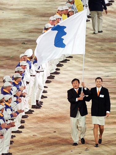 Hai vận động viên Jang Choo Pak (trái) đại diện cho CHDCND Triều Tiên và Eun-Soon Chung của Hàn Quốc thể hiện tinh thần thể thao khi cầm chung lá cờ khi diễu hành tại Olympics Sydney 2000.