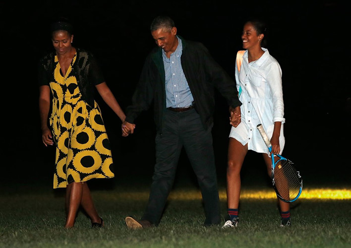Ông Obama, phu nhân và con gái Malia nắm tay nhau khi họ quay trở lại Washington DC sau khi dành thời gian nghỉ ngơi ở Martha’s Vineyard.