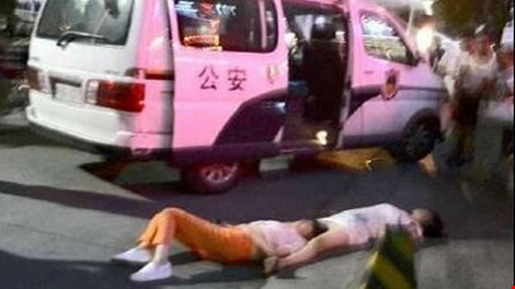Hai phụ nữ Trung Quốc nằm ngất trên đường sau khi đấu khẩu suốt tám giờ đồng hồ. Ảnh: SCMP
