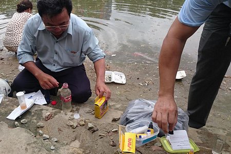 Lực lượng của Chi cục Thủy sản Thừa Thiên-Huế lấy mẫu nước sông đoạn cá nổi và chết để kiểm tra.