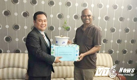 TS. Vũ Văn Thoại (trái) nhận chậu cây giống từ Ngài Joachim Chandran Fernando, bí thư thứ hai đại sứ quán Ấn Độ tại Việt Nam.