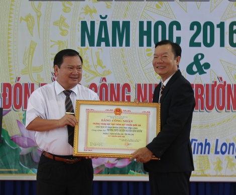 Ông Nguyễn Văn Quang- Chủ tịch UBND tỉnh Vĩnh Long trao bằng công nhận tái đạt chuẩn quốc gia cho thầy Nguyễn Hồng Phước- Hiệu trưởng Trường THPT Chuyên Nguyễn Bỉnh Khiêm (phải).
