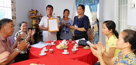 Bà Lê Thị Như Liền (đứng bên phải)- Phó Chủ tịch UBND xã trao quyết định bàn giao nhà cho hộ ông Nguyễn Văn Dũng. 