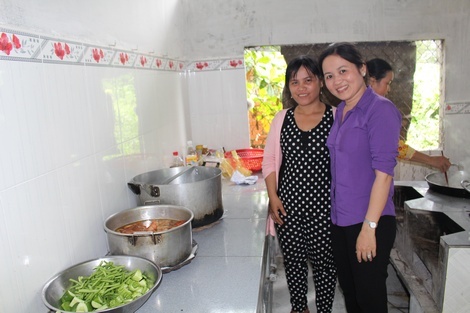 Nữ Chủ tịch UBND xã Tân Phú Phan Thị Loan (phải) cùng chuẩn bị những bữa cơm cho những người xây cầu, với thức ăn do bà con đóng góp.