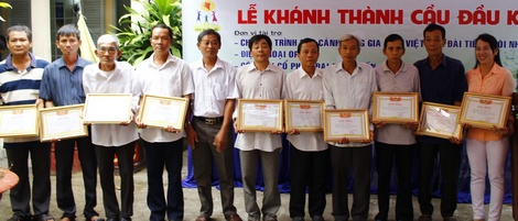 Ông Lê Văn Sáu- Bí thư Đảng ủy xã (thứ 5 từ trái qua) tặng giấy khen cho người dân xã tích cực đóng góp xây dựng cầu Đầu Kinh.
