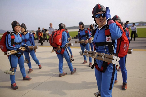 Các phụ nữ Triều Tiên tham gia nhảy dù chuẩn bị lên máy bay trực thăng vào hôm 25/9 tại sự kiện nói trên.