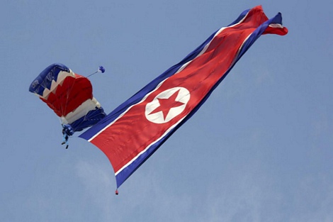 Hai người đầu tiên trong đội hình nhảy dù mang theo quốc kỳ Triều Tiên và cờ đảng Lao động Triều Tiên.