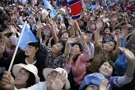 Phụ nữ Triều Tiên vẫy cờ và hò reo trước màn nhảy dù ấn tượng.