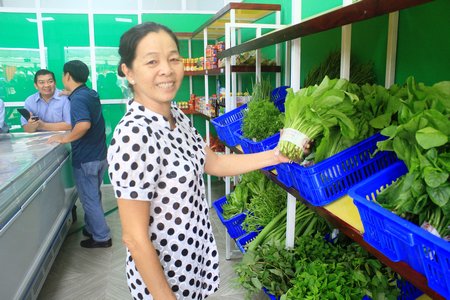 Người tiêu dùng yên tâm khi mua thực phẩm an toàn tại cửa hàng. Trong ảnh: Người tiêu dùng chọn mua rau an toàn Phước Hậu. 