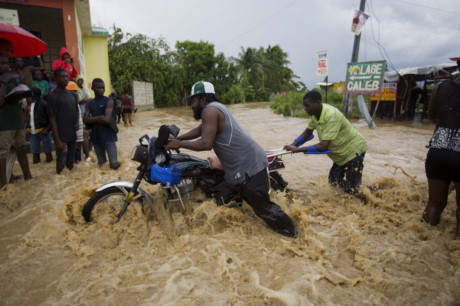 Người đàn ông đẩy xe trong nước lũ ở Haiti. (Nguồn: AP)
