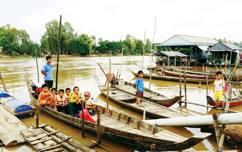 Anh Bùi Văn Tú - xã Breichrai, huyện KosThum, tỉnh Kandal (Campuchia) cho biết, do nước trên đồng chưa có nhiều, không thể giăng câu lưới nên anh tranh thủ dùng ghe chở các em học sinh (Trường Tiểu học An Khánh An) qua sông, mỗi lượt 1.000 đồng/học sinh, người lớn thì 2.000 đồng/lượt