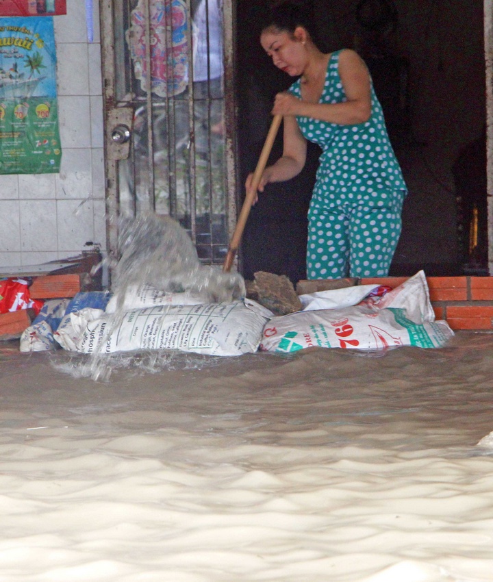 Còn ở trong nhà, người dân ở thị trấn Long Hồ chống chọi với nước ngập.