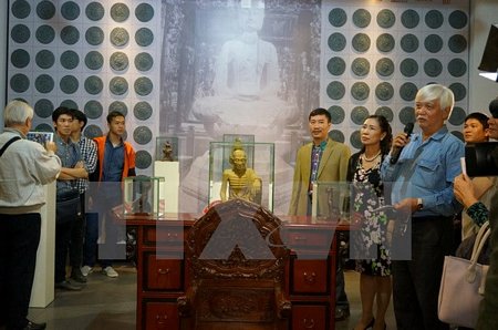 Các đại biểu tìm hiểu các hiện vật tại triển lãm 'Di sản Việt Nam - Góc nhìn mới.' (Ảnh: Đinh Thuận/TTXVN)