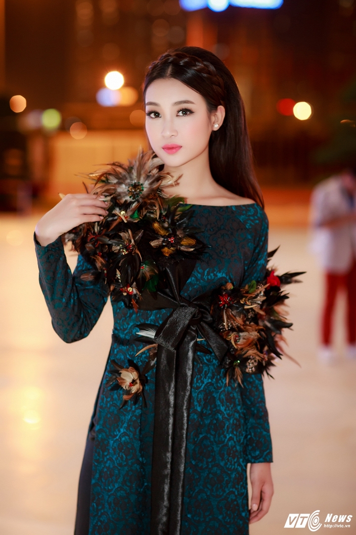 Hoa hậu Việt Nam 2016 lựa chọn bộ áo dài có phom dáng cổ điển màu xanh thẫm bằng vải lụa cao cấp với điểm nhấn là những chiếc lông vũ được đính cầu kỳ quanh ngực áo.