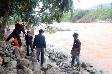 Lực lượng chức năng huyện Ninh Sơn tập trung gia cố đê bao Sông Dinh bị xói lở. (Ảnh: Công Thử/TTXVN)