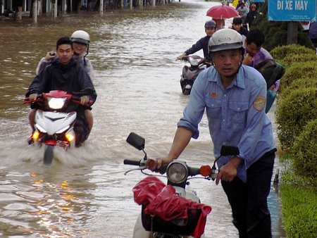 Người dân đẩy xe máy trên phố vì nước ngập sâu