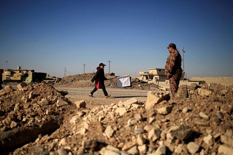 Cậu bé ở làng Kokjali cầm cờ đi qua một chốt kiểm soát của lực lượng đặc nhiệm Iraq.