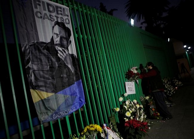 Một người đàn ông đặt hoa tưởng niệm ngoài hàng rào cổng Đại sứ quán Cuba tại Mexico. (Nguồn: Reuters)