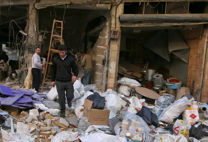 Những người đàn ông nhặt nhạnh những gì còn sót lại khi cửa hàng của họ bị bom đạn tàn phá