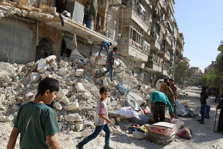 Người dân Syria sống ở khu vực Al-Qaterji lân cận Aleppo tìm kiếm đồ đạc còn sót lại trong đống đổ nát